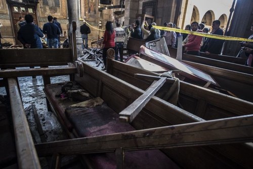 Egyptian security forces (L) inspect the scene of a bomb explosion at the Saint Peter and Saint Paul Coptic Orthodox Church on December 11, 2016, in Cairo's Abbasiya neighbourhood.
