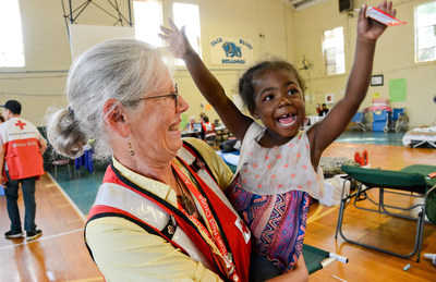 Red Cross volunteer Mary Martin spends time with a 3-year-old shelter resident in Fair Bluff, North Carolina during Hurricane Matthew in October 2016.