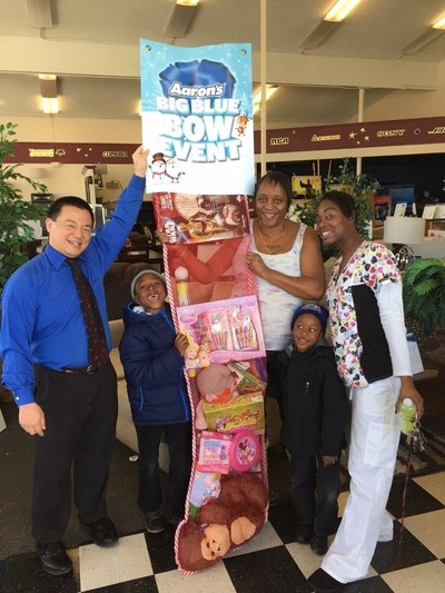 (L to R) Aaron's General Manager Mark Yonemura, with California Grandmother Ophelia Blanchard, her daughter-in-law Sheila and two grandsons, proudly receive their giant stocking filled with toys.  Aaron's, Inc., a leader in the sales and lease ownership and specialty retailing of furniture, consumer electronics, home appliances and accessories, this December is giving away 1,435 giant stockings filled with toys and games to deserving families across the U.S.