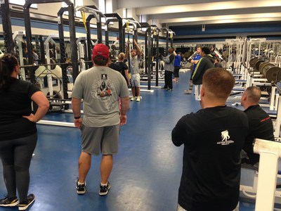 Wounded veterans watch a John Hopkins University trainer demonstrate an exercise.