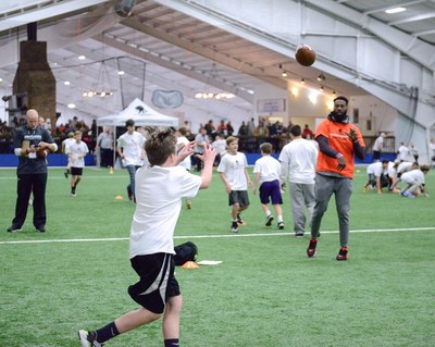 Cincinnati Bengals Brandon LaFell throws a football to a kid during a Wounded Warrior Project hosted football camp.