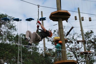 A veteran zips across from above during a Wounded Warrior Project outing to Cocoa Beach Aerial Adventures. 