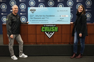 Topgolf Entertainment Group Co-Chairman and CEO Erik Anderson presents Why Not You Foundation Executive Director Carly Young with $10,000 check to support Seattle youth.