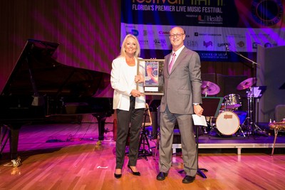 Shelton G. 'Shelly" Berg, Dean at the University of Miami Frost School of Music presents Canon Solutions America's Valerie Belli with a plaque for their support of the Dizzy Gillespie Tribute.