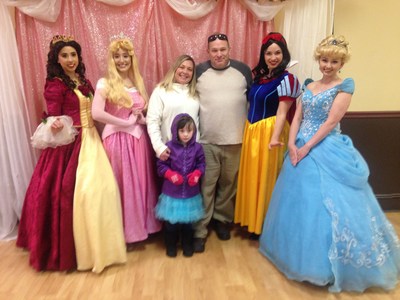 A veteran and his family poses with some of his daughter's favorite princesses.