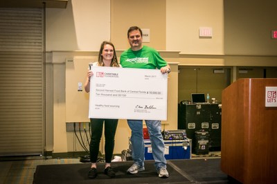 Jillian Butler, corporate social responsibility specialist at BJ's Wholesale Club (left) presents Greg Higgerson, vice president, development, at Second Harvest Food Bank of Central Florida (right) with a donation of $10,000 from BJ's Charitable Foundation to help improve access to healthy meals for thousands of families.