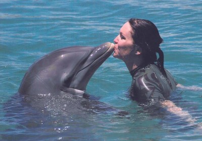 Barbara Huntress Tresness with dolphin as she inspires others in her journey to pay it forward