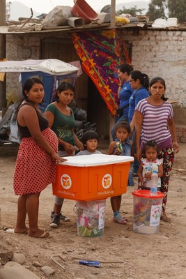 Familias desplazadas en Huachipa, Peru, reciben paquetes con articulos para higiene personal de Direct Relief con articulos esenciales como jabon, cepillos de dientes y otros suministros. Credito: Andrew Curtis/Hitchhiker Pictures
