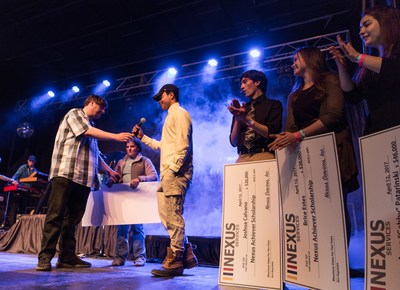 Mike Donovan, CEO and president of Nexus Services, presents Nexus scholarship winners with checks before Nate Ruess takes the stage at community concert in Verona, Virginia.