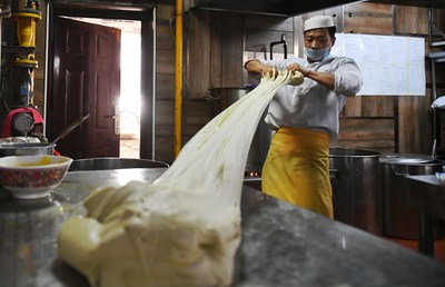 A chef mixes dough to make beef noodle at Alalan Beef-Noodles-Themed Restaurant in Chengduan District in Lanzhou, capital of northwest China's Gansu Province, April 12, 2017.