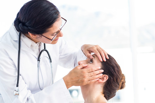 Ophthalmologist examining female patient