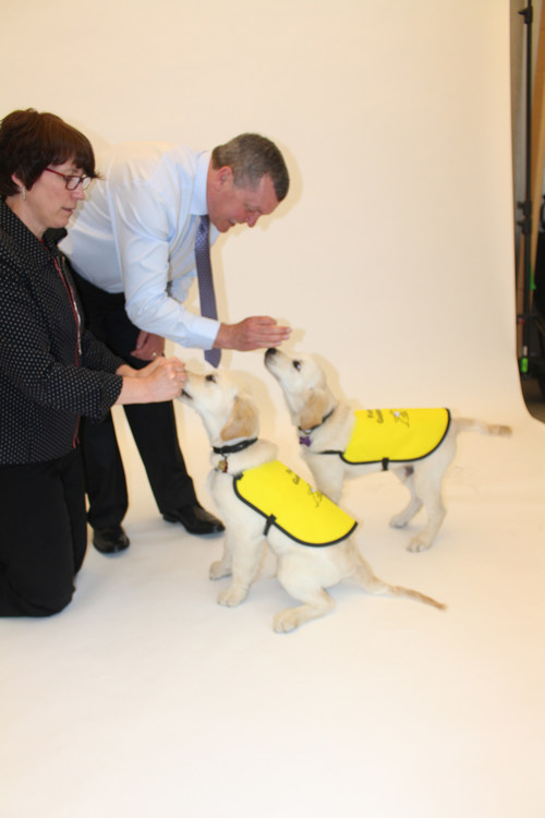 Guide dogs-in-training practice commands with their trainers Andrew and Karen. (CNW Group/CNIB)