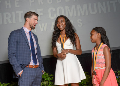 Olympic gold medalist Michael Phelps congratulates Ayomide Okuleye, 17 (center) and Debora Abera, 11 (right), on being named the District of Columbia's top two youth volunteers for 2017 by The Prudential Spirit of Community Awards. Ayomide and Debora were honored at a ceremony on Sunday, May 7 at the Smithsonian's National Museum of Natural History, where they each received a $1,000 award.