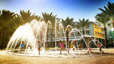 Children play in the Camana Bay fountains