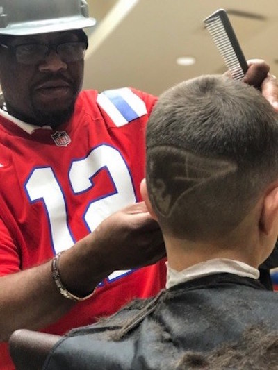 Euan Davis cutting customer's hair.