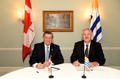 Uruguay’s Minister of Foreign Affairs, Rodolfo Nin Novoa (seated left) signs agricultural food security partnership with Steve Fabijanski, President and CEO of Agrisoma Biosciences Inc. (seated right) (CNW Group/Agrisoma Biosciences Inc.)