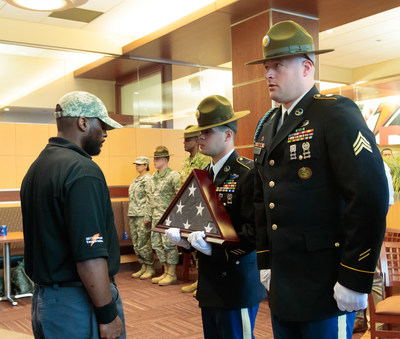 Thomas Skaggs of Pepsi accepts the flag from the United States Army Color Guard