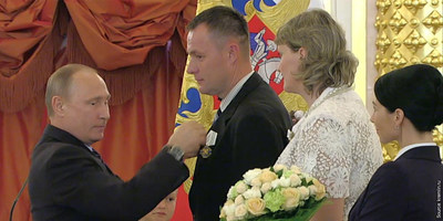 Valeriy Novik, a father of eight, receiving the Order of "Parental Glory" medal from President Putin.