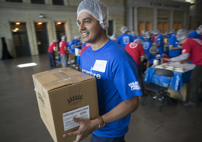 Accenture employee Suraj Bhardwaj adds a box of hunger relief packages to the pile of 15,200 pounds of food packed and donated to the Daily Bread Food Bank during Accenture's annual employee meeting in Toronto, Ont. on Friday, June 16, 2017. A total of 100,000 meals and $10,000 were donated by Accenture. The Canadian Press Images PHOTO/Accenture (CNW Group/Accenture)