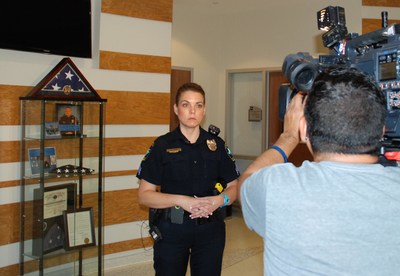 Following gifts of Thin Blue Line Shields of Strength given by Atlanta-based nonprofit, Point 27, to the Little Elm, Texas Police Department Monday, Sgt. Nicole Shaw prepares to do a television interview in the public safety center, in front of a display case with mementos honoring a fellow- and fallen-officer Detective Jerry Walker. Walker was shot in the line of duty January 17.