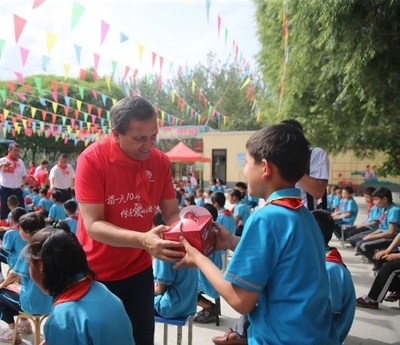 Micky Pant, Yum China CEO, with students from Ye Yi Li Gan Elementary School in Xinjiang