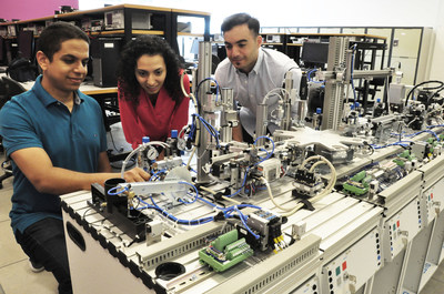 Simon Fraser University Instructor Amr Marzouk shows new state-of-the-art industrial training assembly line equipment to SFU mechatronics students Anahita Mahmoodi and Mouataz Kaddoura. Both are enrolled in the Siemens Mechatronics Systems Certification Program that starts in August 2017. (CNW Group/Siemens Canada Limited)