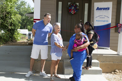 Retired NFL quarterback Kurt Warner and his wife Brenda greet new St. Louis homeowner Kamerial and her children before a surprise unveiling of a home full of furniture donated by Aaron’s, Inc. and its divisions Aaron's and Progressive Leasing.  The awarded home was a result of a partnership of Aaron’s, U-Haul, Habitat for Humanity Saint Louis, and Kurt Warner and his wife Brenda’s First Things First Foundation (FTFF).