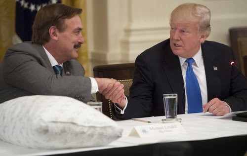 President Donald Trump shakes hands with Mike Lindell (L), founder of MyPillow, during a Made in America event with US manufacturers in the East Room of the White House in Washington, DC, July 19, 2017.