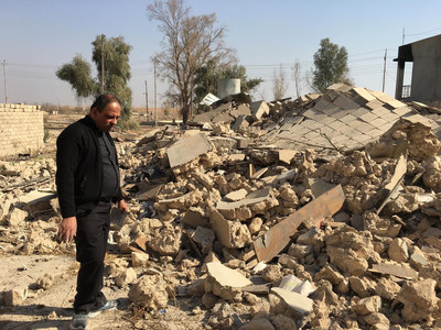 A Catholic church ruined by ISIS in Karamdes, Iraq, is examined by a priest following the predominately Christian town's liberation.
