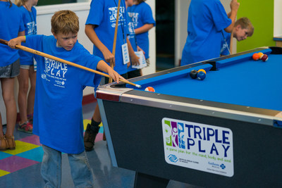 Boys & Girls Club youth plays pool at the organization's new Gamesroom.