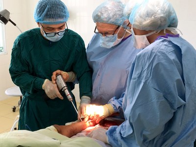 AOFAS volunteer surgeons Michael B. Strauss, MD, FACS (middle) and Isabella V. van Dalen, MD, PhD (right) demonstrate surgical technique to a local surgeon at the Viet Duc Hospital in Hanoi, Vietnam.