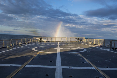 A rainbow is visible in LCS 9's "rooster tail" during Builder's Sea Trials on Lake Michigan. At top speed, LCS 9’s four water jets move approximately 2 million gallons of water per minute producing a 30-foot wall of water known as a rooster tail. That’s enough water to fill an Olympic swimming pool in 20 seconds.