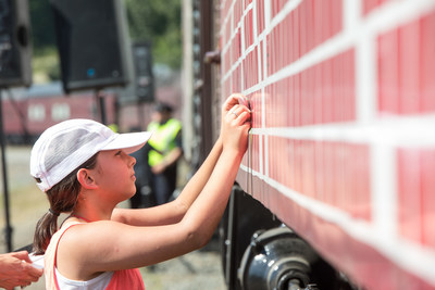A girl places a dream for Canada on the Spirit of Tomorrow car. (CNW Group/Canadian Pacific)