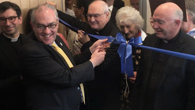 EWTN Chairman and Chief Executive Officer Michael P. Warsaw cuts a ceremonial ribbon at the dedication of EWTN's first studio and office in the United Kingdom. The Most. Rev. Alan Hopes, Bishop of East Anglia (center), and Monsignor John Armitage, Rector of the Shrine of Our Lady of Walsingham (right), look on. (Photo credit: EWTN/Alan Holdren)