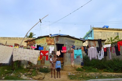 A family stands outside their home in the Dominican Republic. Homes like this one are unlikely to be able to withstand the force of Hurricane Irma. (CNW Group/World Vision Canada)