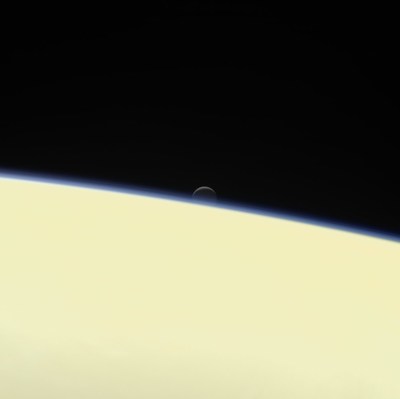 Saturn's active, ocean-bearing moon Enceladus sinks behind the giant planet in a farewell portrait from NASA's Cassini spacecraft. This view of Enceladus was taken by NASA's Cassini spacecraft on Sept. 13, 2017. It is among the last images Cassini sent back. Credit: NASA