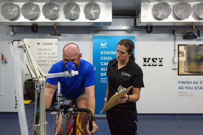 Gabrielle Giersch, a Ph.D. student and KSI assistant director of athlete performance and safety, looks on while Ryan Curtis, a Ph.D. student and KSI associate director of athlete performance and safety, rides an exercise bicycle at the MISSION Heat Lab at the Korey Stringer Institute at Gampel Pavilion on Sept. 21, 2017. (Peter Morenus/UConn Photo)