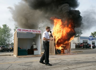 Illinois fire official Mike Figolah narrates a fire and sprinkler burn demonstration.