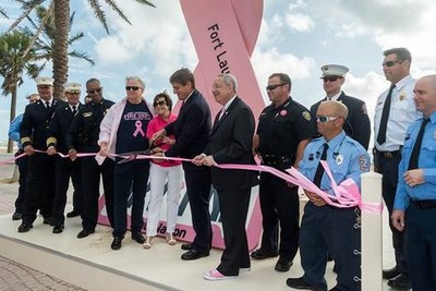 Mike Jackson, Chairman, CEO and President of AutoNation is joined by City of Fort Lauderdale Mayor Jack Seiler and members of the  Police & Fire Departments to unveil a 20 Foot Pink Ribbon on Fort Lauderdale Beach (PRNewsfoto/AutoNation, Inc.)