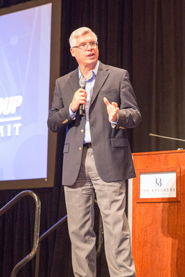 United Franchise Group CEO Ray Titus announces the newest addition to UFG's umbrella of franchise concepts, Paramount Tax & Accounting, during his speech at UFG’s annual Leadership Summit.