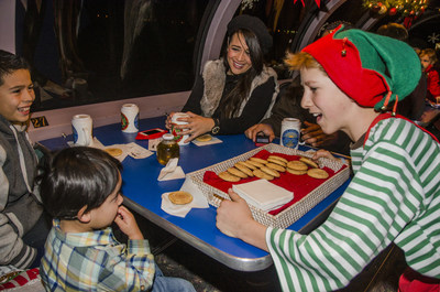 This happy elf is serving cocoa and cookies on the Train to Christmas Town, in the dome car.