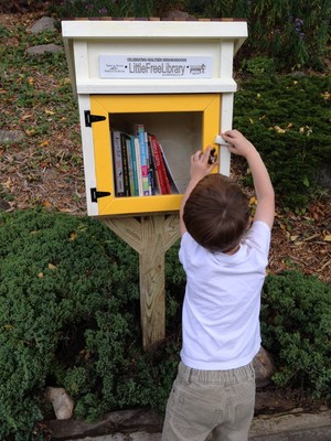 Young boy uses a Little Free Library book exchange in Minneapolis, MN