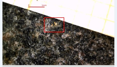 Photo 1: Sample 243174 (642 g/t gold), visible gold (in red box) found as disseminated grains in biotite-quartz granofels. (CNW Group/Mawson Resources Ltd.)