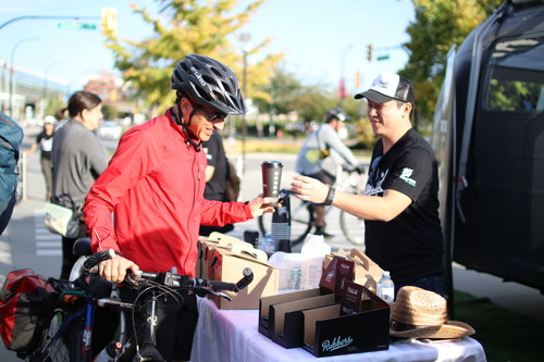 Ziwei Zhang, Developer at Traction on Demand, passes out free coffee to commuters during the 2016 Bandit Tour for Good Kick-Off. (CNW Group/Traction on Demand)