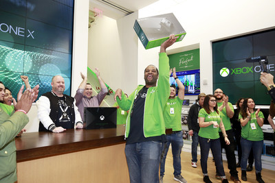 An Xbox fan celebrates being the first to purchase the new Xbox One X console at the flagship Microsoft Store on Fifth Avenue
