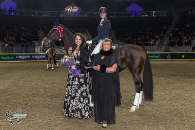 Megan Lane aboard Caravella was presented with the Butternut Ridge Trophy by Emily Hill (left) and Deborah Kinzinger Miculinic as the overall winner of the $20,000 Royal Invitational Dressage at the Royal Horse Show in Toronto, ON. Photo by Ben Radvanyi Photography (CNW Group/Royal Agricultural Winter Fair)