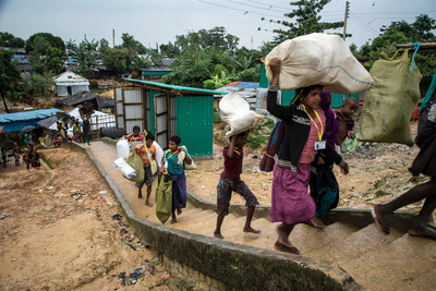 Des rfugis rohingyas transportent leurs effets personnels et tentent de se frayer un passage dans les alles sinueuses du camps de Kutupalong,  Cox's Bazar, au Bangladesh (20 octobre 2017).  UNICEF/UN0140916/LeMoyne (Groupe CNW/UNICEF Canada)