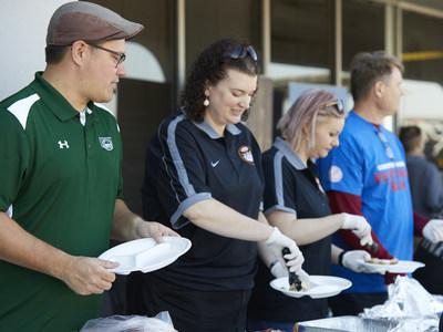Employees serving the Thanksgiving meal to attendees.