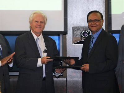 HelpMeSee chairman James Tyler Ueltschi (left) exchanges signed agreements with ISMSICS chairman Dr. Amulya Sahu (right) during a ceremony in Chennai, India.
