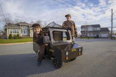 Sur la photo : Cooper ( gauche) et Jax ( droite) font l'essai du mini camion de livraison UPS. (Groupe CNW/UPS Canada Ltee.)